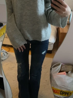 Ljusgrå stickad tröja - Mysig ljusgrå stickad tröja med avslappnad passform och rund halsringning.  Storlek xs