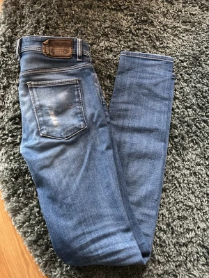 Diesel  jeans blå herr - Snygga blå Diesel jeans med klassisk femficksdesign och skinnpatch bak i midjan. Jeansen har en smal passform och är tillverkade i mjukt bomullsjeansmaterial. Perfekta för en avslappnad och trendig look.
