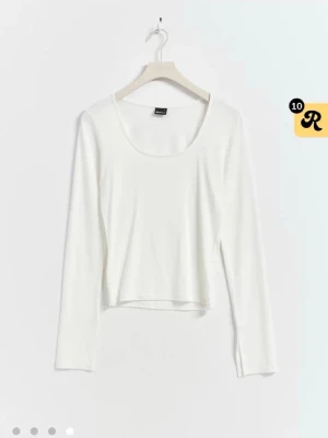 Vit croppad långärmad topp - En enkel och stilren vit croppad topp med långa ärmar och rund halsringning. Perfekt att matcha med höga jeans eller kjol för en clean look. Tillverkad i mjuk bomull för skön känsla hela dagen. Med slits