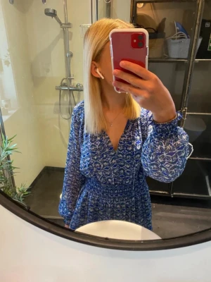 Blå mönstrad kortklänning med v-ringning - Blå klänning i fint mönster från Zara! Använd fåtalet gånger så i väldigt fint skick