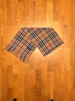 Beige Burberry halsduk - Säljer är beige halsduk från Burberry. Halsduken är gjord i 100% kashmir och är i fint skick. Var inte rädd för några frågor. Pris diskuteras inte!