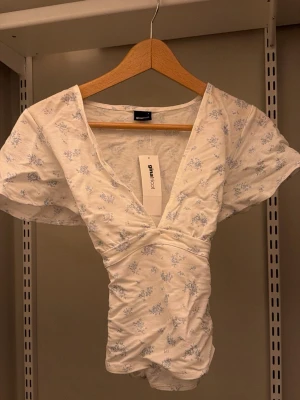 Blommig omlott topp - Blommig omlott topp med knytning samt v uringning🤍.                                                                         Nypris 280:-