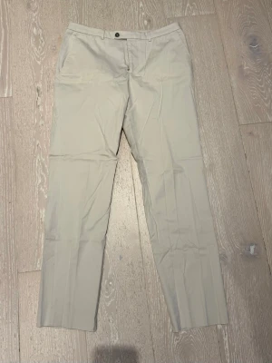 Beige chinos med raka ben - Säljer ett par snygga chinos från OJ! De är i nyskick endast använda 2ggr, och har riktig schysst kvalitet. De är i storlek ”38” vilket passar de som har W32 i jeans. Hör av dig vid fler frågor eller funderingar!