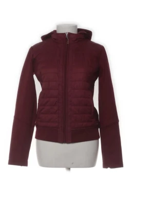 Mörkröd vindjacka med huva - Snygg mörkröd vindjacka med quiltade partier och huva. Jackan har dragkedja framtill och ribbade muddar vid ärmslut och nederkant. Perfekt för vår/höst när du vill ha en stilren look. Lappen är av så står varken storlek eller märke, tycker den sitter som en S.