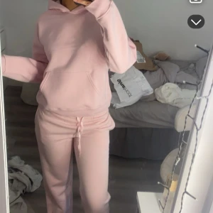 Ljusrosa hoodie med huva - Mysig ljusrosa hoodie med huva och magficka. Tröjan har en relaxed passform och är tillverkad i mjukt material, perfekt för chill dagar. Långa ärmar och klassisk design utan tryck eller mönster.