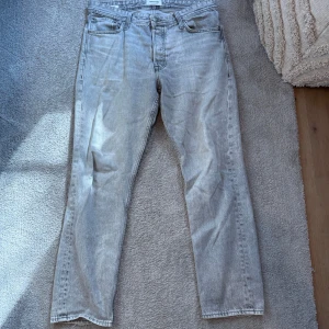 Ljusgrå jeansbyxor och Calvin Celin tröja  - Säljer ett par ljusgrå jeansbyxor med en klassisk femficksdesign. Byxorna har en loose passform och är tillverkade i ett slitstarkt denimtyg. Perfekta för en avslappnad stil.