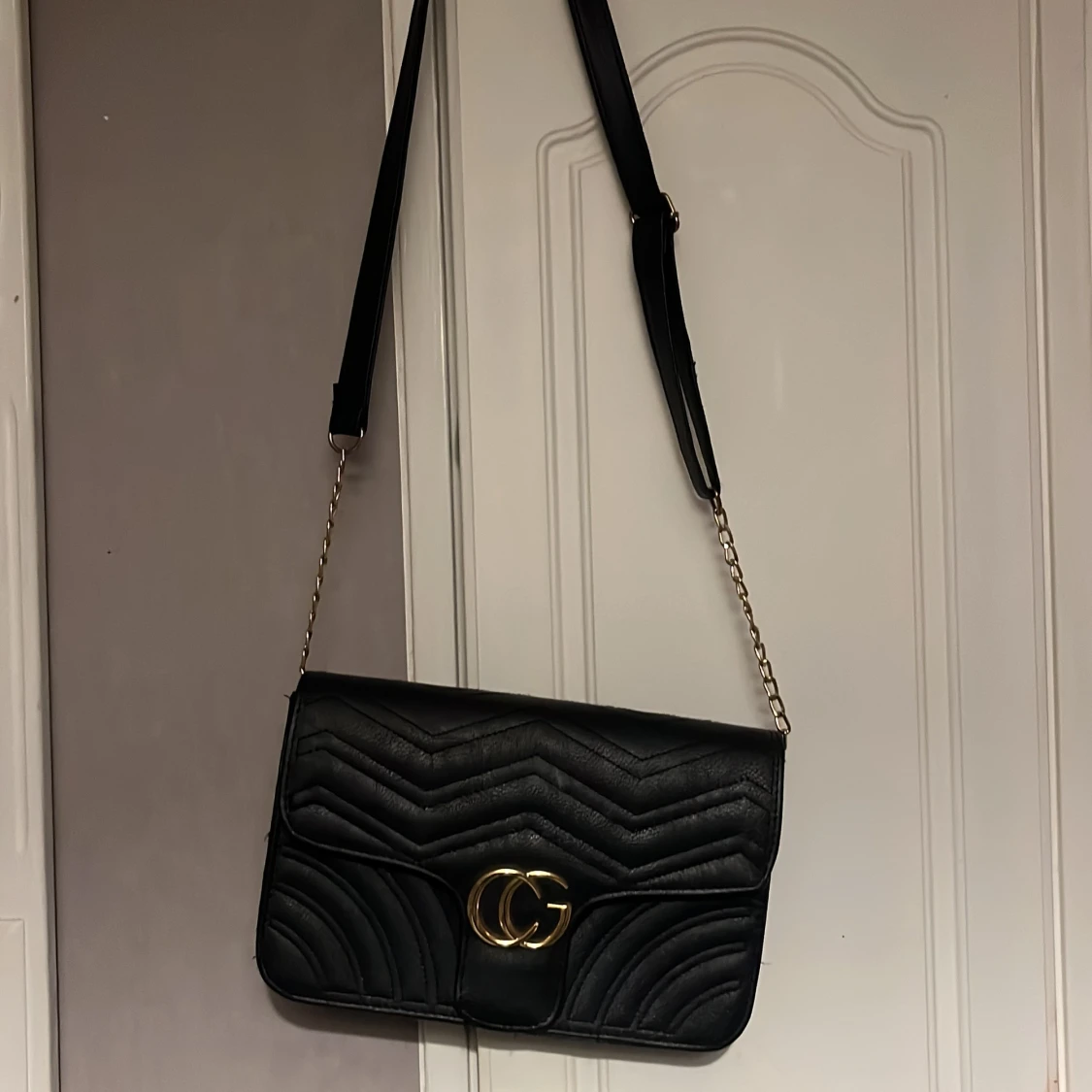 Svart axelväska med gulddetaljer