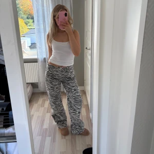 Zebramönstrade wide jeans - Säljer ett par riktigt snygga zebramönstrade jeans med svartvita ränder. Byxorna har en loose och wide passform med låg midja och klassisk femficksdesign. Perfekta för dig som vill sticka ut och addera lite edge till din outfit.