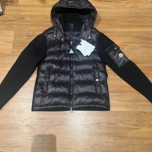 Moncler cardigan - Hej säljer en svart glossy moncler cardigan storken är M men passar S och Scan fungerar säljer den eftersom att den inte passar mig och Scan fungerar