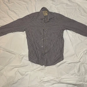 Rutig skjorta Scotch & Soda M - Snygg och vit rutig skjorta från Scotch & Soda Company. Skjortan har klassisk krage, långa ärmar och knäppning framtill. Det står storlek M men den känns som storlek S. En fin skjorta från ett snyggt märke.