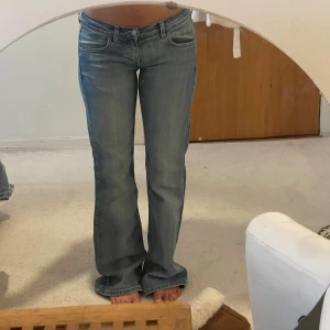 Snygga jeans  - Säljer ett par snygga bootcut jeans från planet. Jeansen har klassisk femficksdesign, låg midja och subtila slitningar för en cool look. Tillverkade i mjuk denim med stretch för extra komfort. 