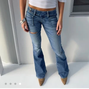 Intresskoll Blå bootcut jeans med fickor - Blåa lågmidjade jeans med hål i ,dom är i strlk xs. Kan tänka mig och sälja vid bra bud
