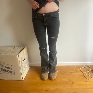 Mörkgråa bootcut jeans med slitningar - Säljer mina mörkgråa Gina tricot jeans som jag själv har gjort rivor i! De är lågmidjade och med en bootcut 💗Så snygga! Storlek 34/S