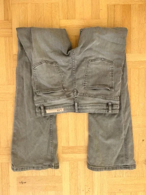 Grå bootcut jeans från LAB - Säljer ett par gråa bootcut jeans från LAB med klassisk femficksdesign och snyggt slitna detaljer. Jeansen har normal passform och är tillverkade i mjukt bomullsmaterial med en lätt tvättad look. Perfekta för dig som gillar en avslappnad stil.