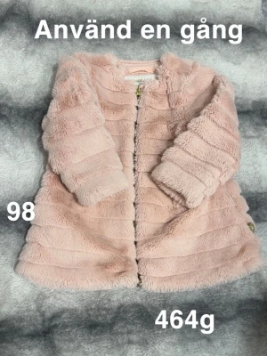 Ljusrosa pälsjacka i storlek 98 - Supersöt ljusrosa pälsjacka med mjuk och fluffig känsla. ( ej äkta päls) Jackan har långa ärmar och stängs med dragkedja framtill. Perfekt för dig som vill ha en mysig och stylish look till de kallare dagarna.🌸 Använd en gång. Mjuk och skön. Storlek 98