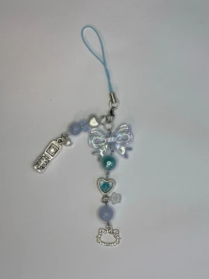 Blå hello Kitty mobilhänge med pärlor och rosett 💙 - Nyckelring eller accessoar till väska/ mobil. Handgjort 💙