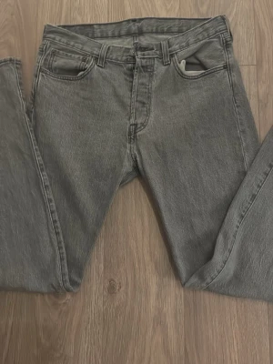 Grå jeans straight fit - Säljer ett par grå jeans med klassisk femficksdesign och rak passform. Jeansen har bälteshällor och stängs med dragkedja och knapp. Perfekta till en avslappnad stil och funkar året runt.