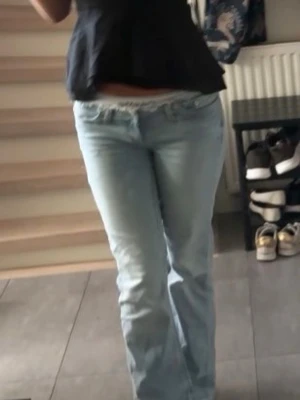 Ljusblå bootcut jeans - Säljer ett par ljusblå jeans med bootcut passform. De har låg midja och klassisk femficksdesign. Jeansen är tillverkade i denim och har en avslappnad vibe som passar perfekt till sneakers eller boots.
