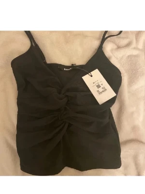 Svart glittrig topp  - Säljer en svart glittrig topp från Bikbok i storlek XS. 