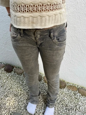  LTB jeans - Säljer ett par grå jeans från LTB med snygg tvättad look och detaljer som dubbla knappar i midjan och dragkedja på fickan. Modellen är lågmidjad och har raka ben med normal passform. Passform 160-165, brukar ha 34-36 i jeans!🙌💖Använd fåtal gånger!