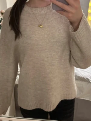 Beige stickad tröja med rund hals - Mysig stickad tröja från Gina tricot köpt för 399kr helt ny fick i julklapp men inte riktigt min stil så därav säljes den. Prislapp kvar och inga defekter alls då den ej används. Beige i färgen och modellen ”knitted crewneck shirt”💕