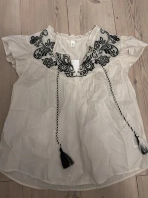 Kortärmad tröja med spets detaljer  - En jättefin kortärmad tröja från hm. Perfekt till sommaren. Lite skrynklig på bild en så snygg på. Helt ny och original priset är 279kr. Säljer pga att jag köpte två stycken i olika storlekar och hann inte lämna tillbaka❤️