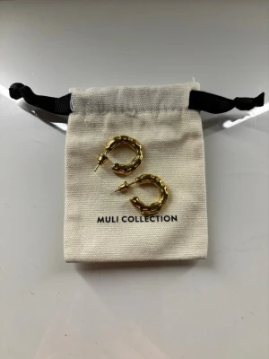 Guldiga hoops - Muli collection - Superfina guldiga hoops från Muli collection, vattentåliga. Dessa heter ’terra hoops’ på hemsidan. Helt nya oanvända. Nypris 499 kr.