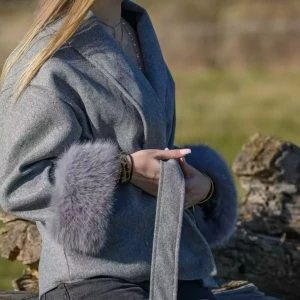 Grå omlottjacka med pälsdetaljer - Snygg grå omlottjacka med bred krage och bälte i midjan. Jackan har fluffiga pälsdetaljer vid ärmsluten som ger en lyxig vibe. Ordpris: 800kr säljer för 450kr