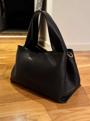 Väska - Sååå snygg väska från Novita. Köpt på Scorett för 1600 kr. Finns inte att köpa längre. Tygpåse och extraband medföljer. Använd vid ett tillfälle, som ny. 