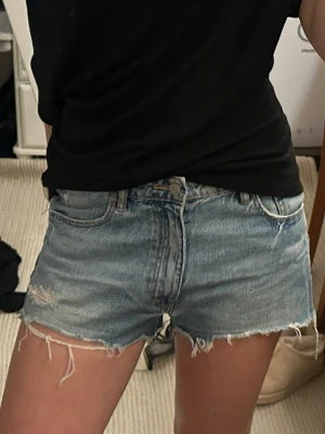 Blå jeansshorts från Gina Tricot - Säljer ett par ljusblå jeansshorts från Gina Tricot kids med fransiga kanter och slitna detaljer. Super fina till sommarn!🙌💖Storlek 164, men passar mig som i vanliga fall brukar ha 34/36 i shorts.