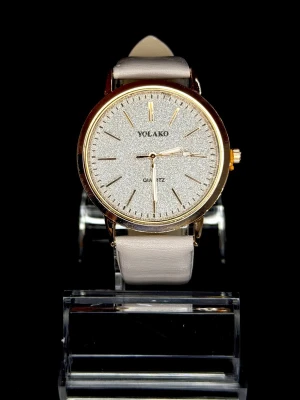 Yolako Champagne Shimmer *Helt ny* - En elegant klocka med guldfärgad boett, skimrande urtavla och ljusbeige läderarmband. Stilren & tidlös – perfekt till både vardag och fest. Quartz-urverk. *Helt ny*