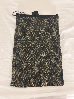 Mini kjol - Kort kjol med tight passform. Guldiga detaljer 