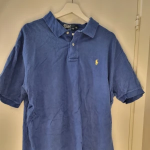 Ralph Lauren pike - Säljer en klassisk pikétröja från Ralph Lauren med korta ärmar. Perfekt för en stilren och avslappnad look.            