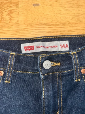 Levi's 512 Slim Taper jeans mörkblå - Mörkblå Levi's 512 Slim Taper jeans med klassisk femficksdesign och snygga kontrastsömmar. Jeansen har smal passform med avsmalnande ben och är tillverkade i slitstarkt denim. Perfekta för dig som gillar en clean och modern look.