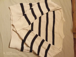 Randig stickad tröja från 157 - Säljer en stickad tröja från 157 i vitt med svarta ränder. Tröjan har rund halsringning, ribbade muddar och lång ärm. Perfekt för dig som gillar klassisk stil med en twist. Materialet är mjukt och skönt, passar bra till höst och vinter. Jag säljer för att jag har växt ur den
