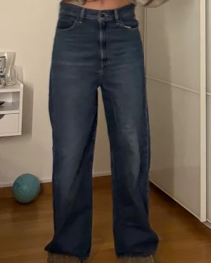 Levi's 501 blå jeans wide fit - Säljer ett par klassiska Levi's 501 jeans i mörkblå tvätt med hög midja och breda, raka ben. Jeansen har fem fickor, knappgylf och den ikoniska Levi's-lappen bak. Perfekt för dig som gillar en loose och avslappnad stil. !!!!Kan diskutera pris!!