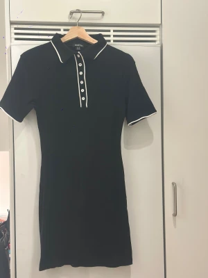 Svart pikéklänning från Boohoo - Materialet är en mix av bomull och polyester med lite stretch så den blir figursydd. Fin till utekväll eller chill.
