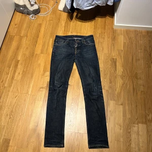 Nudie Jeans Grim Tim  - Säljer ett par Nudie Jeans Grim Tim i färgen Dry Navy. Jeansen är i storlek 33/36 men sitter mer som 31/34