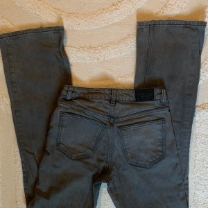 Gråa bootcut jeans med stora bakfickor - Köpt för 399. Säljer ett par gråa jeans med bootcut passform och stora, kantiga bakfickor. Jeansen har en rak siluett och är tillverkade i klassiskt jeanstyg. Perfekta för dig som gillar en avslappnad och retro vibe.