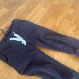 Mörkblå mjukisbyxor med snörning - Mörkblåa mjukisbyxor från RUSSEMERCH med vita snören i midjan och bekväma fickor. Tillverkade i mjuk bomullsmaterial som känns skönt mot huden. De funkar till vardags tex i skolan också då dom är snygga. Sitter väldigt bra, det är storlek xxs och jag skulle säga att dom är normal i storleken. Jag är 1,57 lång och dom passar superbra. köpta för 499 kr från russemerch för inte så länge sedan. Köpta i april 2025 (5 mån sen)