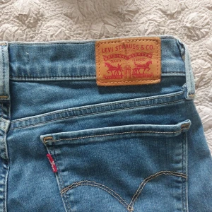 Levi's 710 Super Skinny jeans blå - Säljer ett par klassiska Levi's 710 Super Skinny jeans i ljusblå denim. Modellen har smal passform och normal midja. Ikonisk Levi's-lapp bak och röda loggan vid bakfickan.
