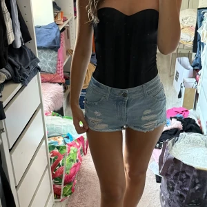 Ljusblå jeansshorts med slitningar - Superfina shorts med ripped detaljer som inte kommer till användning mer. Står att de är i strl 25 vilket ska motsvara strl xs.💕