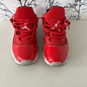 Röda Nike Air Jordan sneakers - Säljer ett par röda Nike Air Jordan sneakers med vit Jumpman-logga på plösen och sidan. Skorna har snörning, svart innerfoder och vit sula med grå detaljer. Ovandelen är i syntetmaterial och textil, med en sportig och clean look.