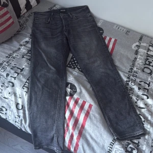 Svarta tapered jeans Tapered/Mike 30/30 - Säljer ett par svarta jeans från Tapered/Mike i storlek 30/30. Jeansen har en snygg tvättad look och klassisk femficksdesign. Modellen är tapered vilket ger en smalare passform nedtill. Perfekta för dig som gillar stilrena och bekväma jeans. De är använda 1-2 gånger och pris kan diskuteras. De är värda 900 egentligen