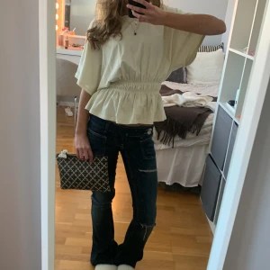 Jättesnygg volang blus/tröja - Säljer en ljusgul blus med bred resår i midjan som ger en snygg volangkant nertill. Blusen har korta, vida ärmar och en lös passform upptill. Perfekt för dig som gillar en avslappnad men ändå söt stil. Materialet känns mjukt och luftigt. Köpte den för ganska länge sen o står inget märke . Den är i storlek XS o skulle säga att den passar om man har S med. Som man kan se kan man ha den på lite olika sätt. Tyvärr är den något lite miss färgad pga tvätt men inte alls mycket o inget som syns 💖💖