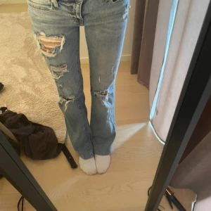 Ljusblåa flare jeans från Aeropostale - Säljer ett par ljusblåa jeans från Aeropostale med flare-ben och snygga slitningar framtill. Jeansen har klassisk femficksdesign, låg midja och är tillverkade i mjukt denimtyg. Perfekta för dig som gillar en avslappnad och trendig look. Midjemått-34 cm och innerbenslängden-74 cm jag är 165