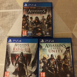 Assassin's Creed PS4 Spelpaket: Syndicate, Rogue Remastered, Unity - Tre populära Assassin's Creed-spel till PS4: Syndicate (Special Edition), Rogue Remastered och Unity. Alla spel med originalfodral och skivor i mycket gott skick. Perfekt för samlare eller fans av actionäventyr. PEGI 18.