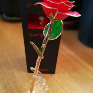 Guldpläterad röd ros från Gorham - Exklusiv röd ros från Gorham, doppad i 24K guld. Rosens kronblad är intensivt röda med guldkant och gröna blad, vilket ger en lyxig och romantisk känsla. Levereras i elegant presentask med äkthetscertifikat. Perfekt som unik gåva eller dekoration.