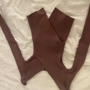 Ribbad brun topp - Supersnygg ribbad topp i brun nyans. Tröjan är v ringad och  har en modern, tight passform. Materialet är stretchigt och ger en cool look.