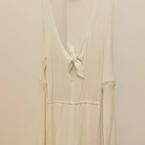 Vit Romper Strandöverdrag - En vit romper från H&M med knytdetalj på framsidan som man kan knyta upp. Har aldrig använts då den är för små! 